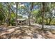 Tan house with gray garage doors and mature landscaping, long driveway at 7408 Oak Run Ln, Sarasota, FL 34243