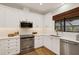Modern kitchen with white cabinets, stainless steel appliances, and quartz countertops at 7408 Oak Run Ln, Sarasota, FL 34243