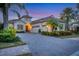 Luxury home with brick driveway, palm trees, and landscaped yard at 7504 Windy Hill Cv, Lakewood Ranch, FL 34202