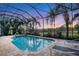 Enclosed pool and spa with lounge chairs and sunset view at 7504 Windy Hill Cv, Lakewood Ranch, FL 34202
