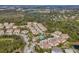 Wide aerial view of community featuring multiple buildings, landscaping, and a pool at 8150 Enclave Way # 104, Sarasota, FL 34243