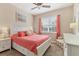 Bright bedroom with coral bedding, and white dresser at 8150 Enclave Way # 104, Sarasota, FL 34243
