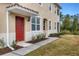 Front entrance of condo with red door and walkway at 8150 Enclave Way # 104, Sarasota, FL 34243
