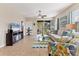 Living room features tile flooring, a large TV, and access to a screened balcony at 8150 Enclave Way # 104, Sarasota, FL 34243