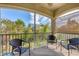 Relaxing screened balcony with wicker furniture and tranquil wooded views at 8150 Enclave Way # 104, Sarasota, FL 34243