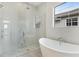 Bright bathroom featuring a glass enclosed shower, soaking tub, and modern windows offering natural light at 8376 Sea Glass Ct, Sarasota, FL 34240