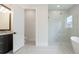 Bright bathroom featuring a glass enclosed shower, soaking tub, double sink vanity, and stylish tile floors at 8376 Sea Glass Ct, Sarasota, FL 34240