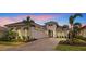 Beautiful home featuring white stucco, black window awnings, two-car garage, paved driveway and manicured landscaping at 8376 Sea Glass Ct, Sarasota, FL 34240