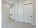 Hallway featuring wood-look tile floors, three white doors and two entries into the house's other rooms at 8376 Sea Glass Ct, Sarasota, FL 34240