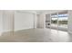 Expansive living room showcasing light gray floors, views of the backyard pool and patio, and sliding glass door at 8376 Sea Glass Ct, Sarasota, FL 34240