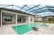Screened-in pool and spa with a gray tile patio that complements the home's white exterior at 8376 Sea Glass Ct, Sarasota, FL 34240
