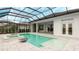 An inviting screened-in pool and spa is complemented by the home's white exterior and lush landscaping at 8376 Sea Glass Ct, Sarasota, FL 34240