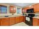 Kitchen with wood cabinets, black appliances, and ample counter space at 8889 White Sage Loop, Lakewood Ranch, FL 34202