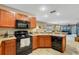 Well-equipped kitchen boasts black appliances and wood cabinetry at 8889 White Sage Loop, Lakewood Ranch, FL 34202