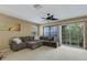 Living room with sectional sofa, ceiling fan, and sliding glass doors to patio at 8889 White Sage Loop, Lakewood Ranch, FL 34202