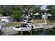 Aerial view of waterfront home with boat dock, tiki bar, and lush landscaping at 1006 69Th W Ave, Bradenton, FL 34207