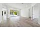 Bright living room with light wood floors and sliding doors to the pool at 11124 Hyacinth Pl, Lakewood Ranch, FL 34202