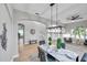 Bright dining room with marble table, modern light fixture, and view to living room at 14146 Cattle Egret Pl, Bradenton, FL 34202