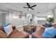 Bright living room with leather sofas, coffee table, and ceiling fan at 14146 Cattle Egret Pl, Bradenton, FL 34202