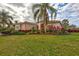House with tile roof, lush landscaping, and a large lawn at 210 166Th Ne St, Bradenton, FL 34212