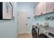 Clean laundry room with washer, dryer, and white cabinets at 210 166Th Ne St, Bradenton, FL 34212
