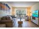 Bright living room with gray sofa, wood-look floors, and balcony access at 3223 Beneva Rd # 201, Sarasota, FL 34232