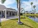 Charming backyard featuring a screened lanai, lush lawn, and a serene waterfront view with swaying palm trees at 3523 52Nd W Ave, Bradenton, FL 34210