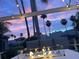 Inviting patio view featuring a fire pit, comfortable seating, string lights, and swaying palm trees under a colorful sky at 3523 52Nd W Ave, Bradenton, FL 34210