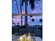 Inviting patio view featuring a fire pit, comfortable seating, string lights, and swaying palm trees under a colorful sky at 3523 52Nd W Ave, Bradenton, FL 34210