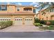 Tan two-story townhome with two-car garage and manicured landscaping at 3665 Square West Ln # 13, Sarasota, FL 34238