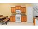 Kitchen features wood cabinets, granite countertops, and white appliances at 3665 Square West Ln # 13, Sarasota, FL 34238