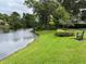 Peaceful waterfront view with a grassy area and bench at 3665 Square West Ln # 13, Sarasota, FL 34238