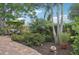 Relaxing brick patio with seating area, lush landscaping, and a green umbrella at 430 Beach Park Blvd, Venice, FL 34285