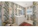 Clean bathroom with white vanity, tropical wallpaper, and tiled floors at 430 Beach Park Blvd, Venice, FL 34285