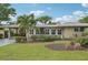 Tan single-story home with palm trees and manicured lawn at 430 Beach Park Blvd, Venice, FL 34285