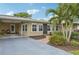 Tan single story home with a landscaped yard and palm trees at 430 Beach Park Blvd, Venice, FL 34285