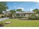 Tan single story home with a spacious lawn and palm trees at 430 Beach Park Blvd, Venice, FL 34285