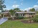 Tan single story home with a landscaped yard and palm trees at 430 Beach Park Blvd, Venice, FL 34285