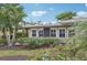Tan home exterior showcasing a manicured landscape and palm trees at 430 Beach Park Blvd, Venice, FL 34285