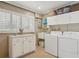 Bright laundry room with washer, dryer, and cabinets at 430 Beach Park Blvd, Venice, FL 34285