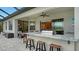 Outdoor kitchen with built-in grill and seating for four at 4810 Sparkling Sea Ln, Bradenton, FL 34211