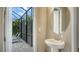Small powder room with a pedestal sink and screened patio view at 4810 Sparkling Sea Ln, Bradenton, FL 34211