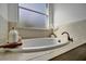 Oval soaking tub with tile surround and window at 5125 Tidewater Preserve Blvd, Bradenton, FL 34208