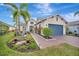 Two-story house with a blue garage door and palm trees at 5125 Tidewater Preserve Blvd, Bradenton, FL 34208