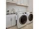 Bright laundry room with white cabinets, a sink, and new washer/dryer at 5125 Tidewater Preserve Blvd, Bradenton, FL 34208