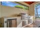 Luxury outdoor kitchen with grill, sink, and beverage fridge at 5125 Tidewater Preserve Blvd, Bradenton, FL 34208