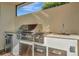 Stainless steel outdoor kitchen with grill, sink, and mini-fridge at 5125 Tidewater Preserve Blvd, Bradenton, FL 34208