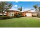 Single-Gathering home with orange exterior and lush lawn at 5203 Lake Overlook Ave, Bradenton, FL 34208