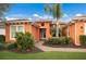Single-Gathering home with orange exterior and lush landscaping at 5203 Lake Overlook Ave, Bradenton, FL 34208