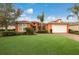 Single-Gathering home with orange exterior and lush lawn at 5203 Lake Overlook Ave, Bradenton, FL 34208